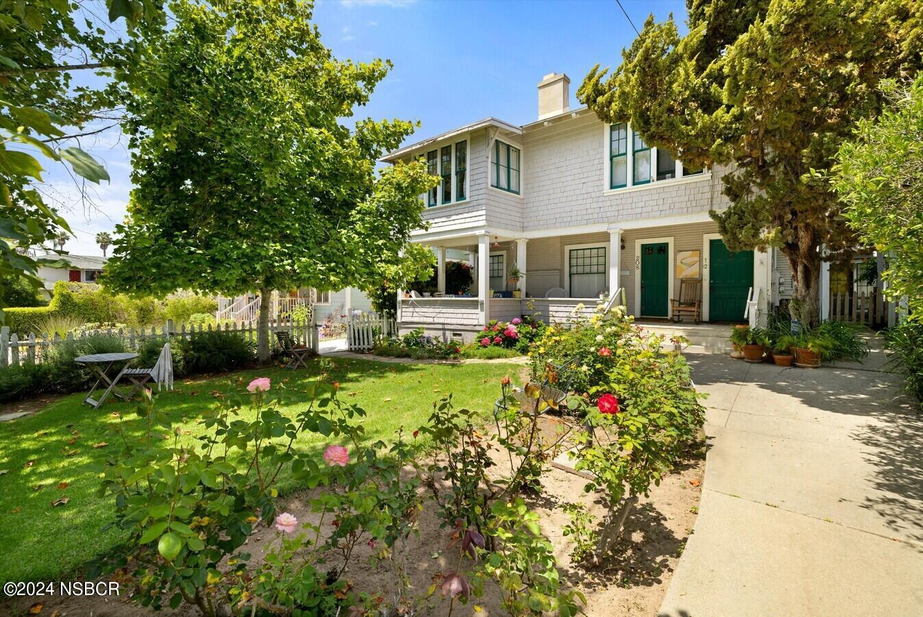 a front view of a house with a yard and potted plants