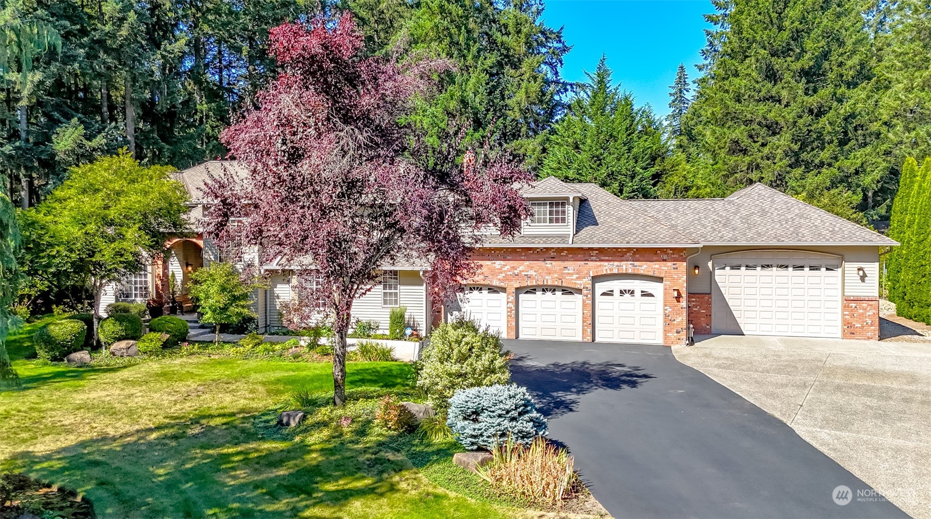 a front view of a house with a garden and trees