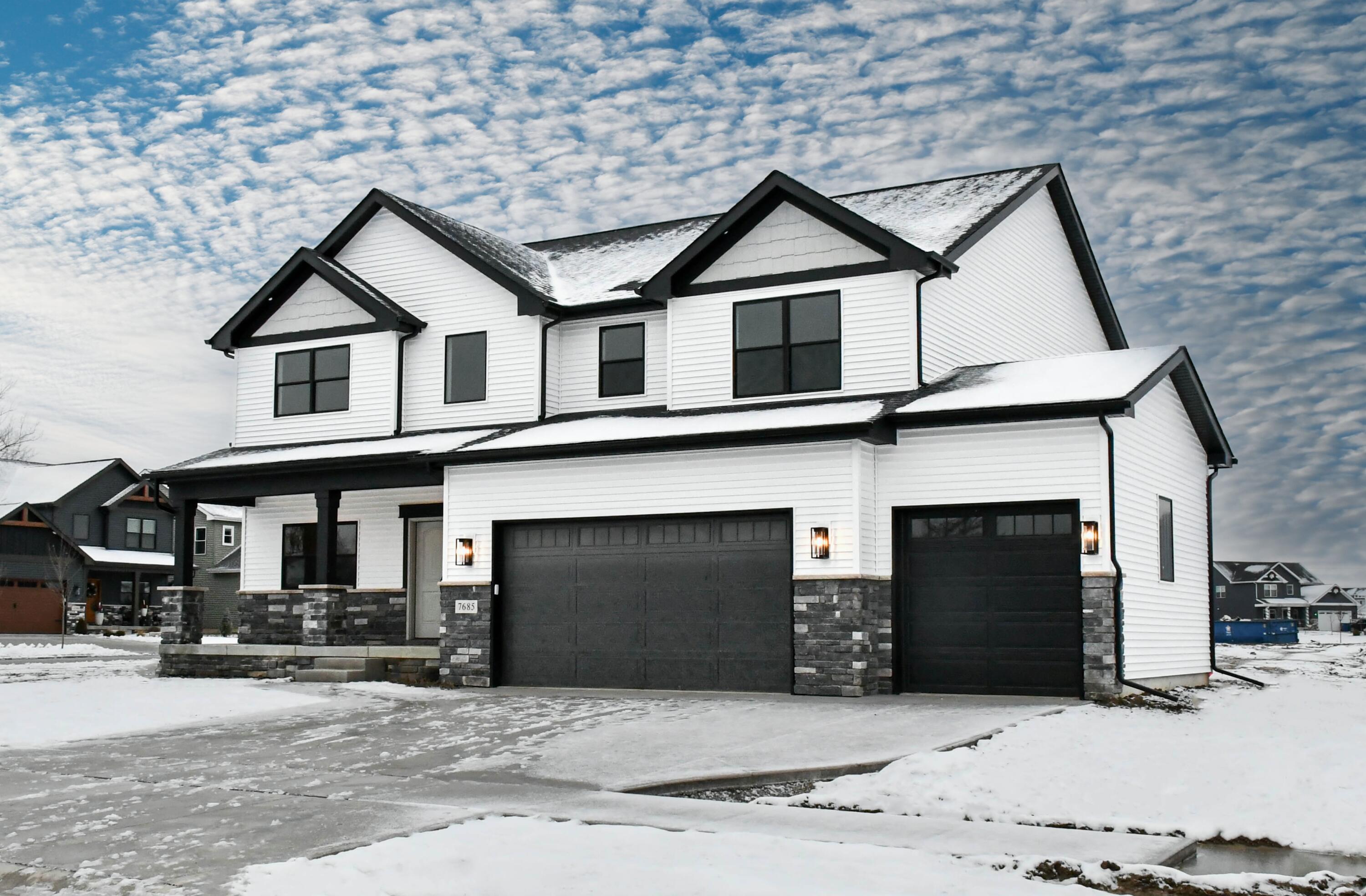 a front view of a house with yard and parking