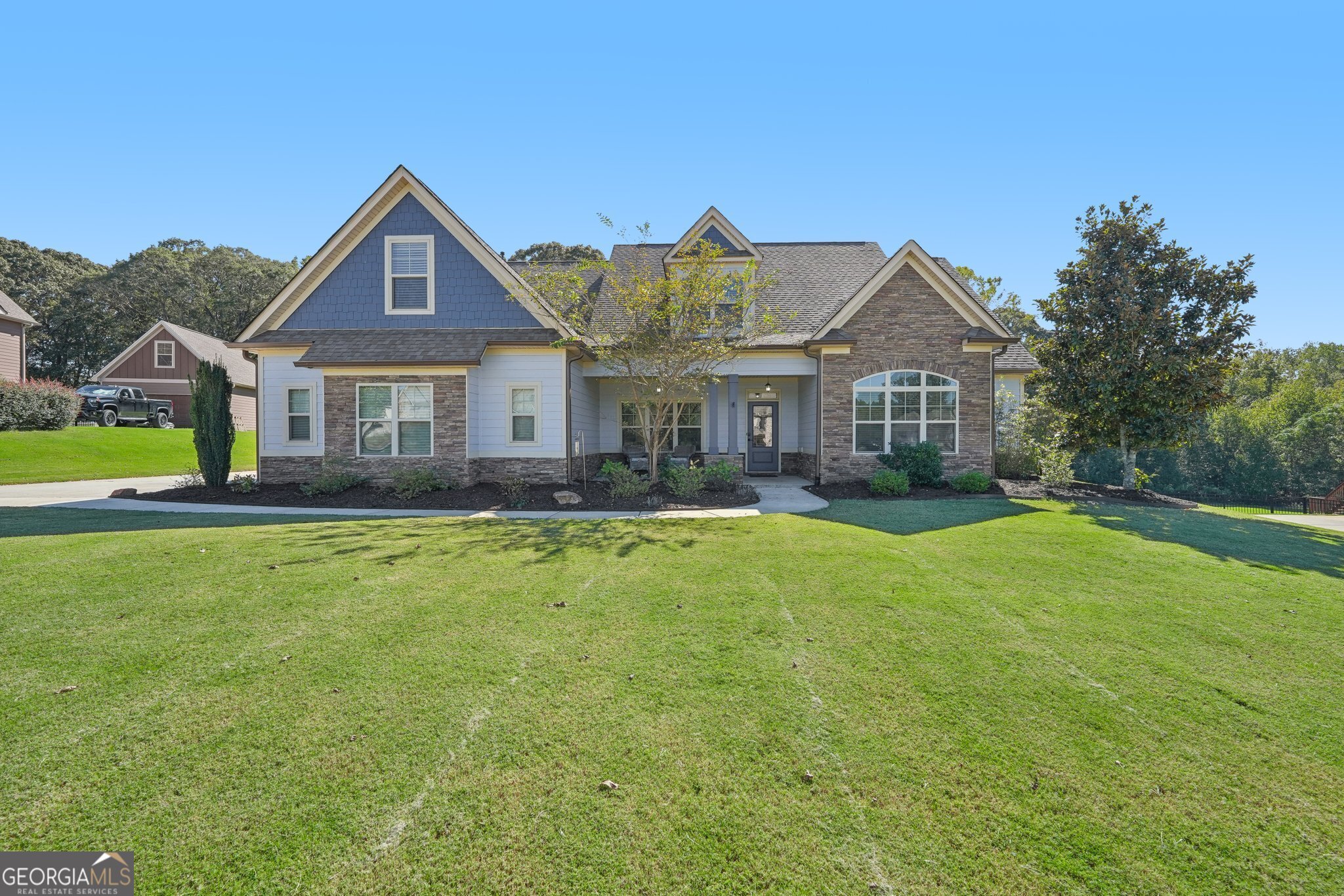 a front view of a house with a yard and trees