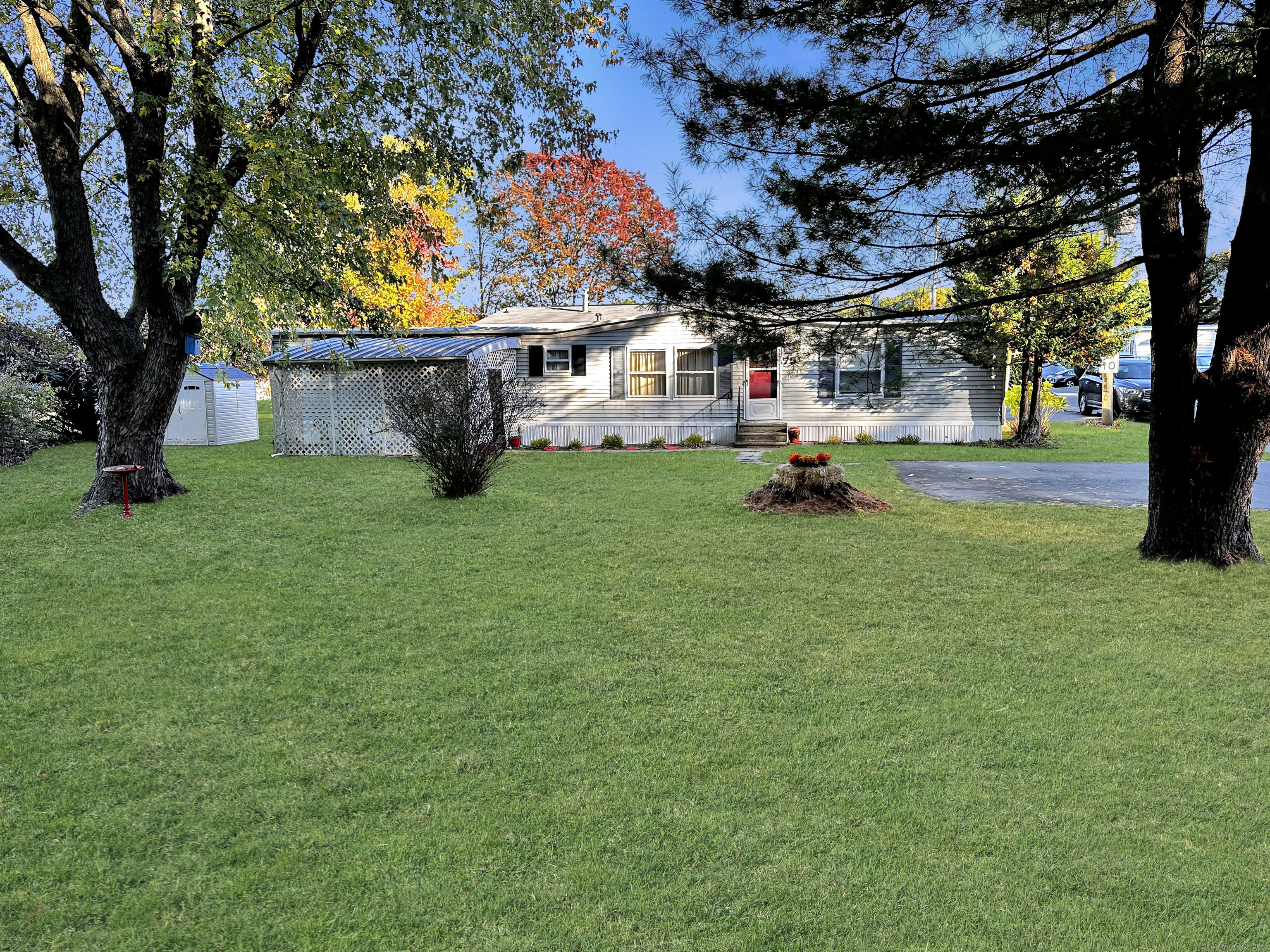 a front view of a house with a garden and tree