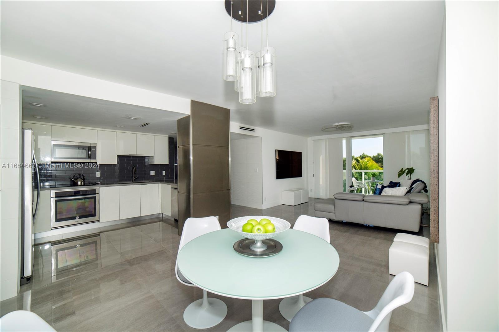 a kitchen with stainless steel appliances wooden floor dining table and chairs