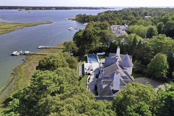 an aerial view of a house with a garden and lake view