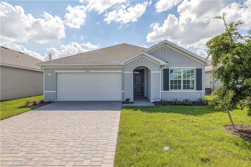 Ranch-style home with a front yard, cooling unit, and a garage