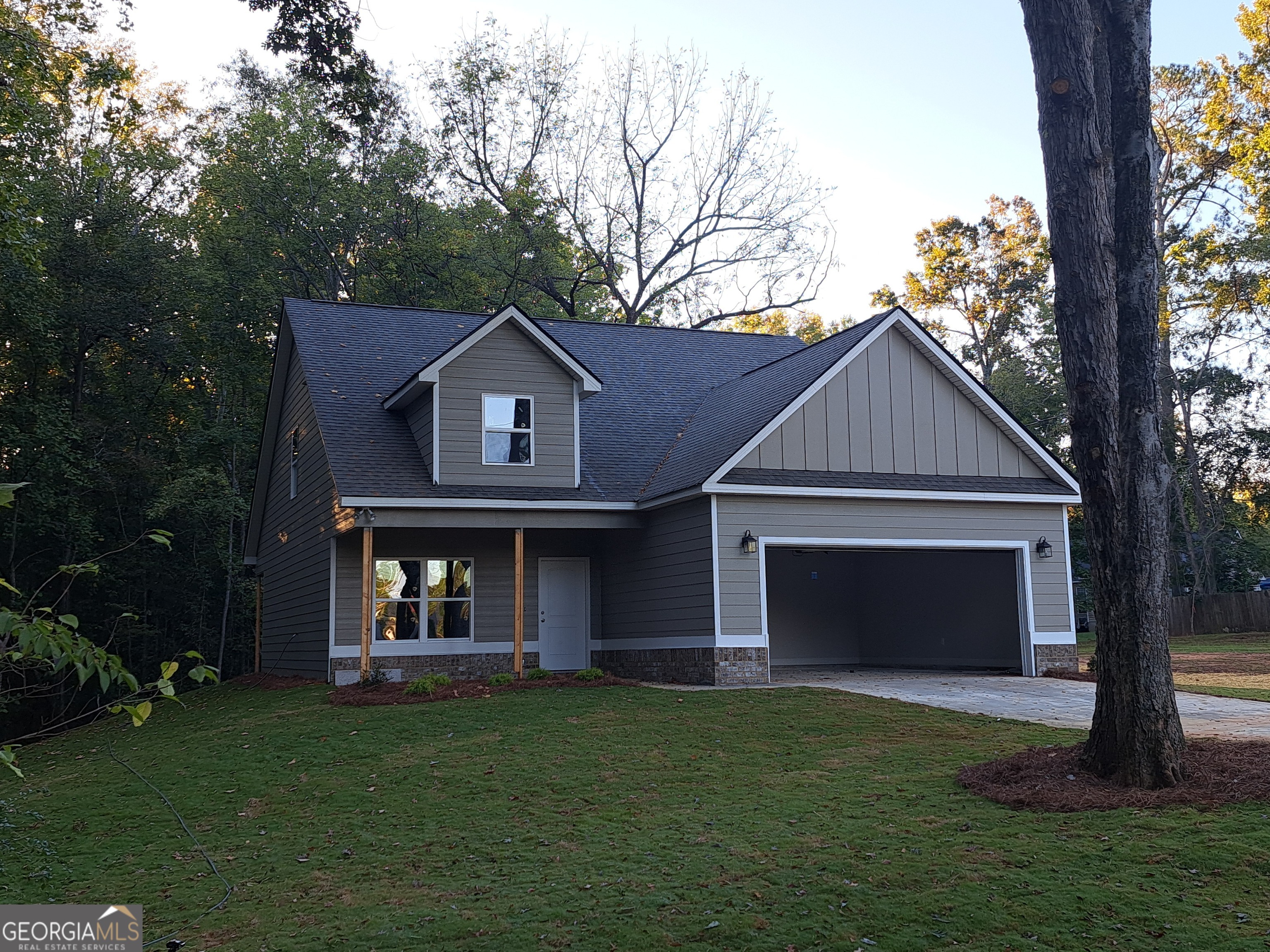 a front view of a house with a garden and yard