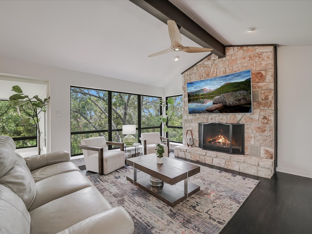 a living room with furniture a flat screen tv and a fireplace