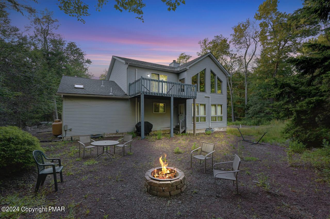 a front view of a house with a yard fire pit and outdoor seating