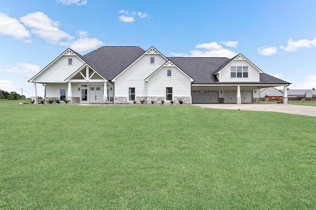 a view of a house with a big yard and large trees