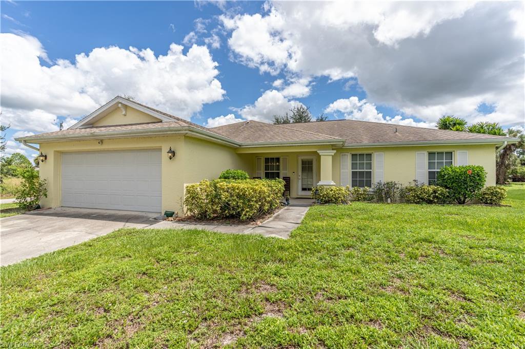 Ranch-style house with a garage and a front lawn