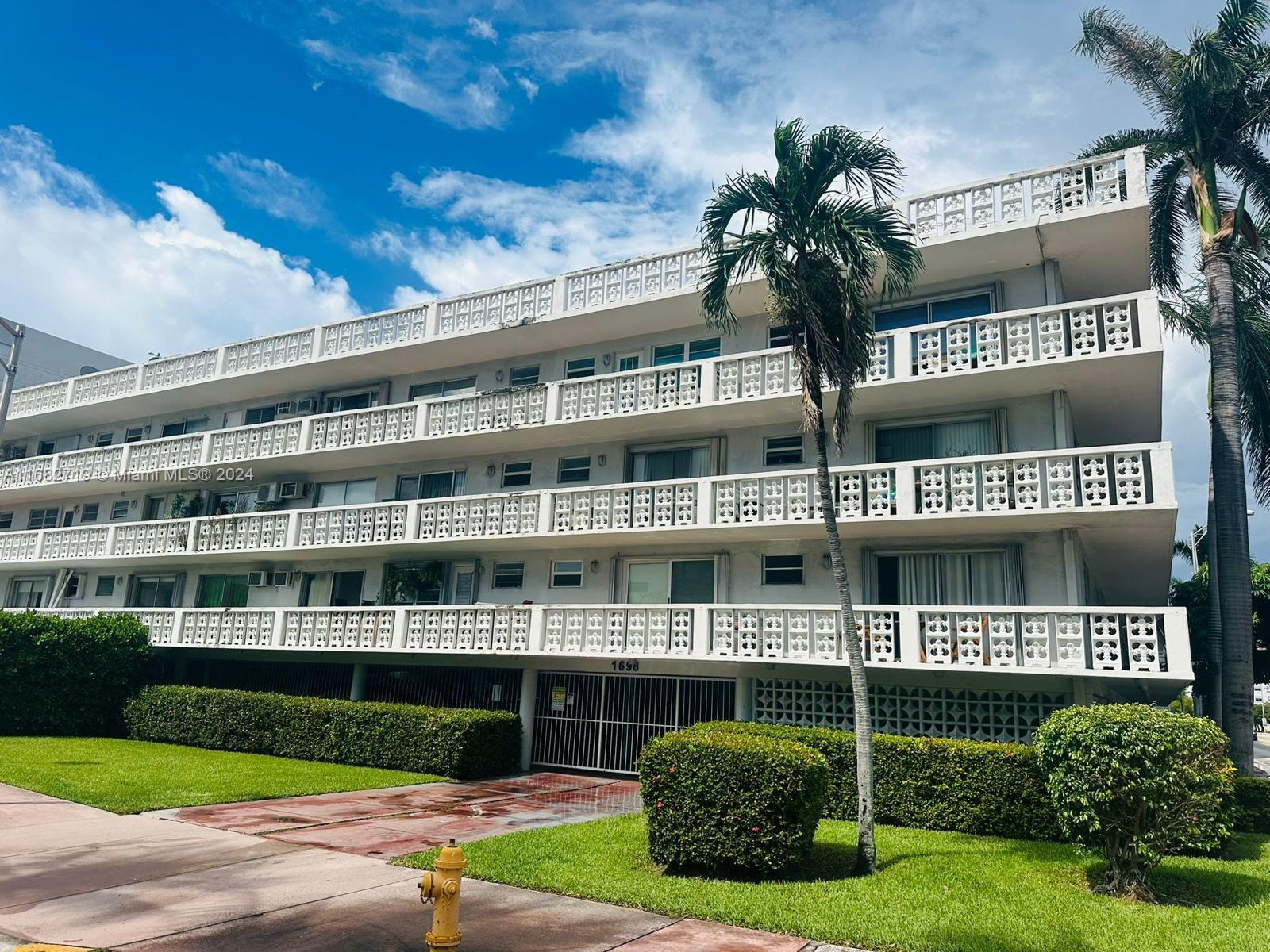 a front view of a building with a garden