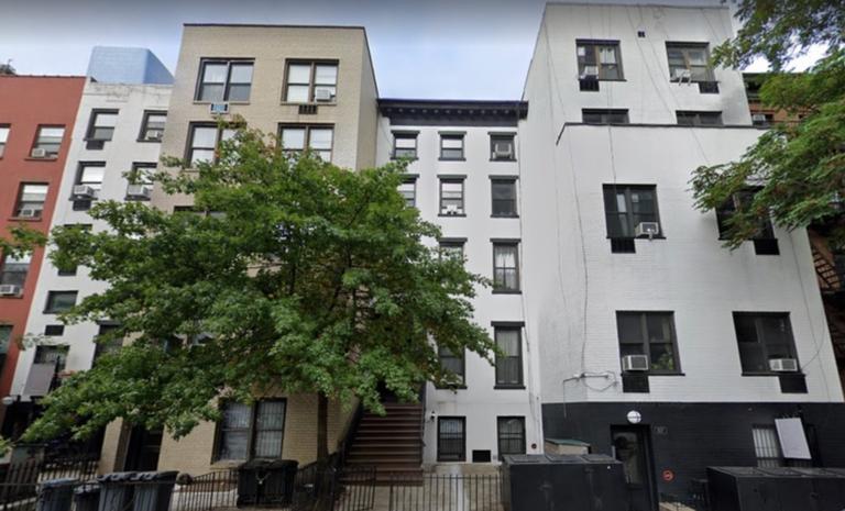 a front view of a building with a tree