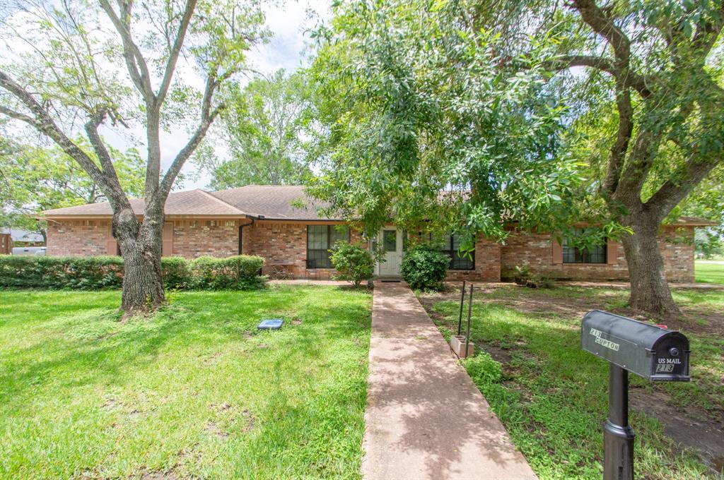 a front view of a house with a yard and trees