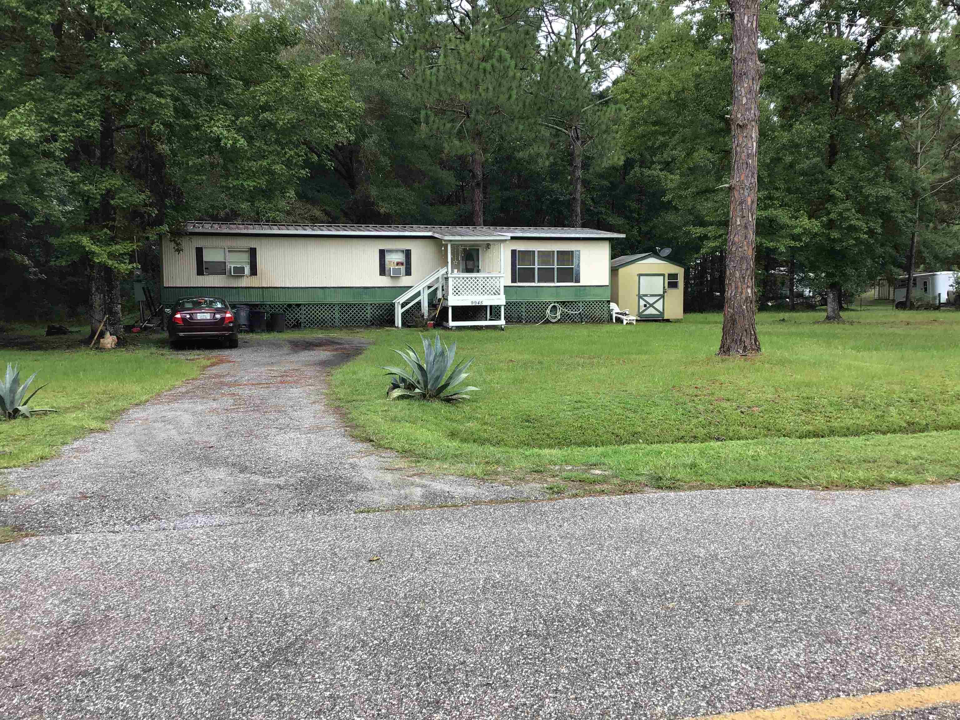 a front view of a house with a yard and trees