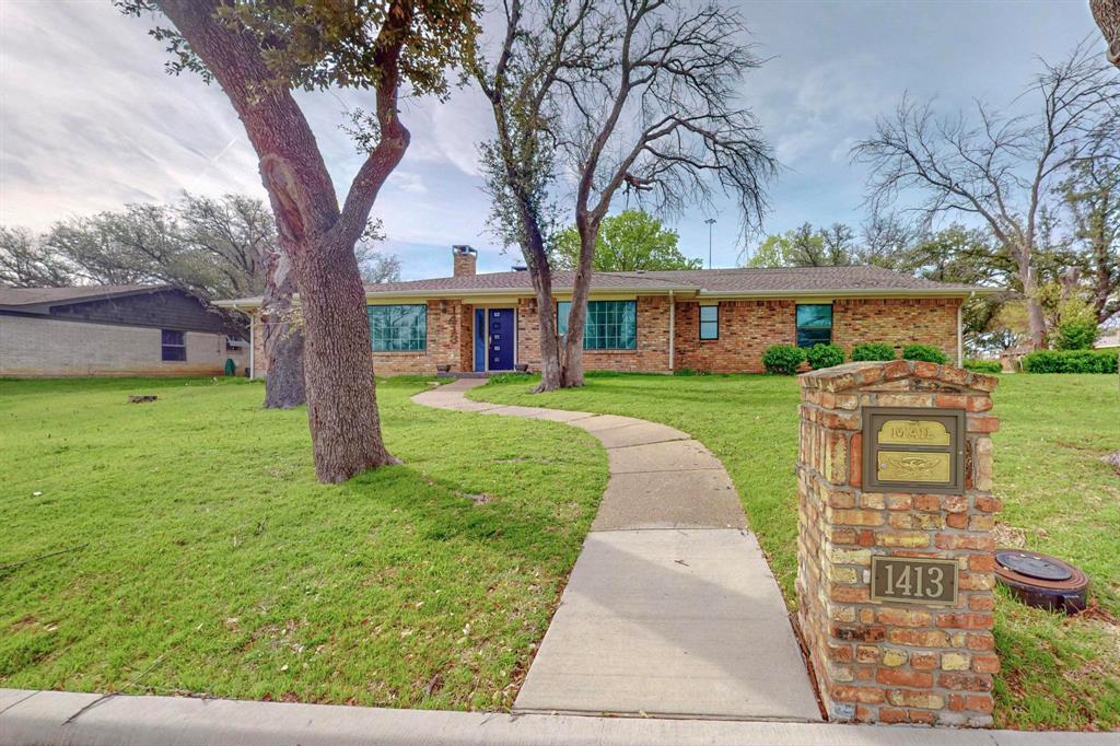 a front view of a house with a yard and trees