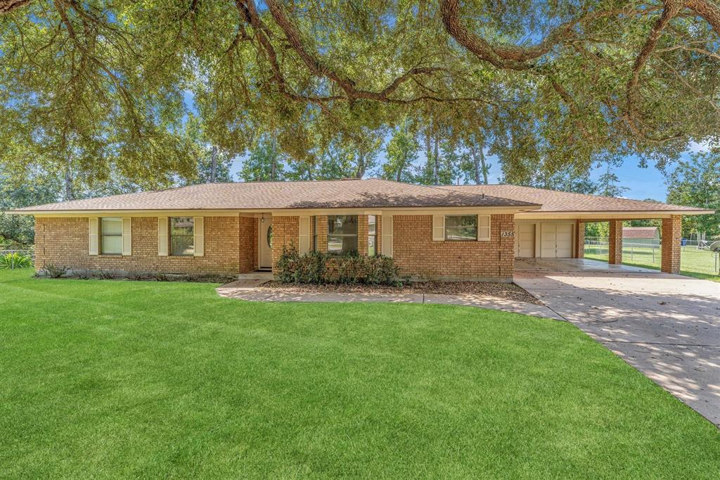 Single-story brick home with a carport, and large front yard.