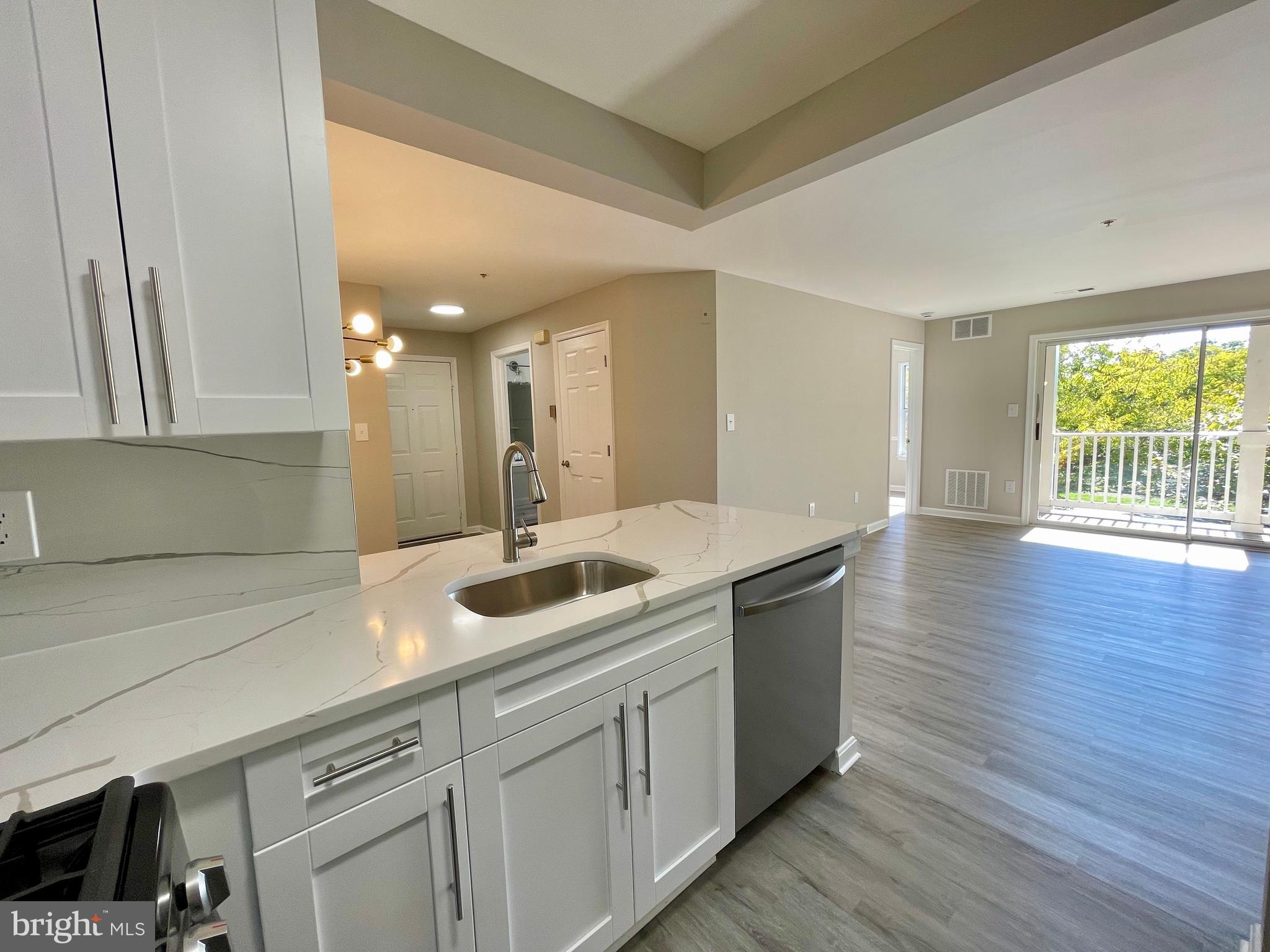 a kitchen with a sink and wooden floor