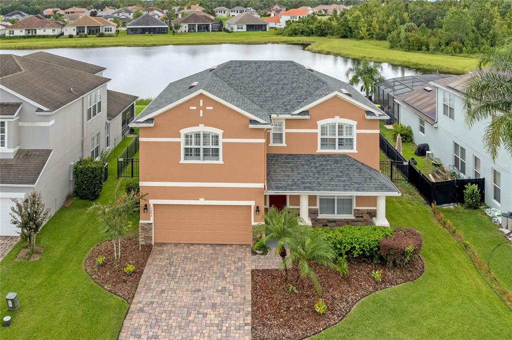 an aerial view of a house with a yard and lake view