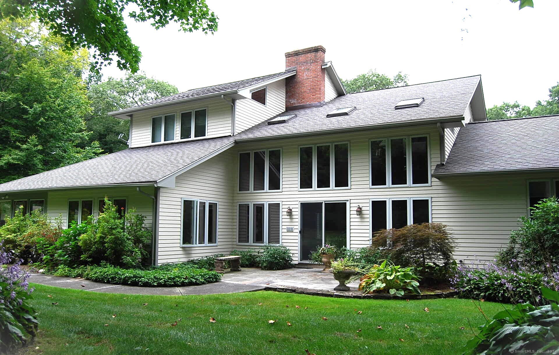 a view of a house with a yard potted plants and a table