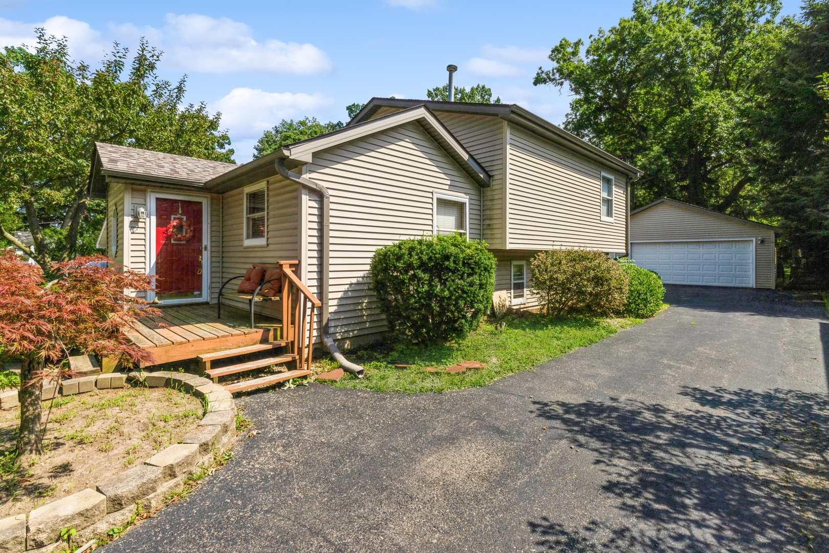 a view of a house with a yard and lawn chairs with wooden fence