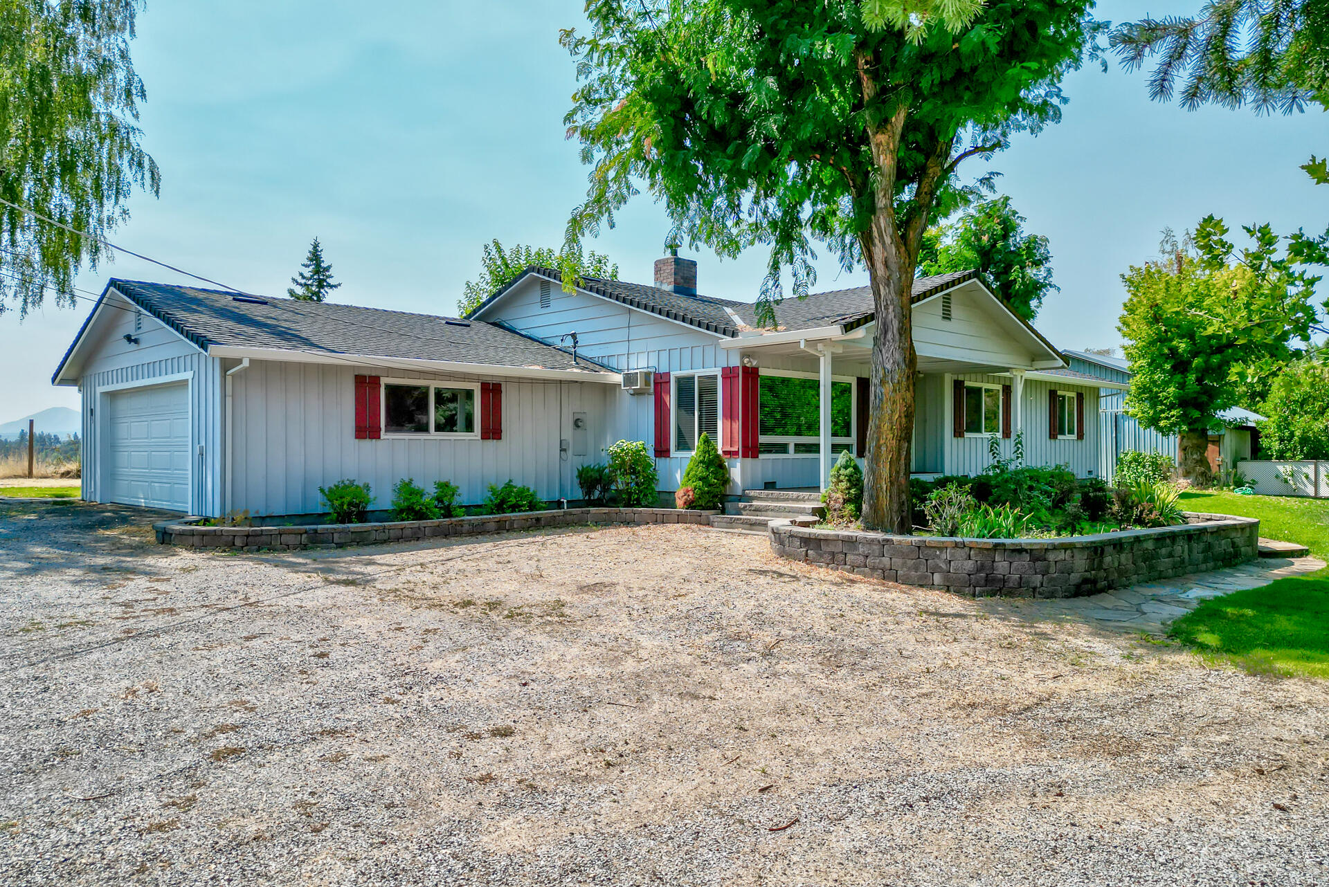 a front view of a house with a yard and potted plants