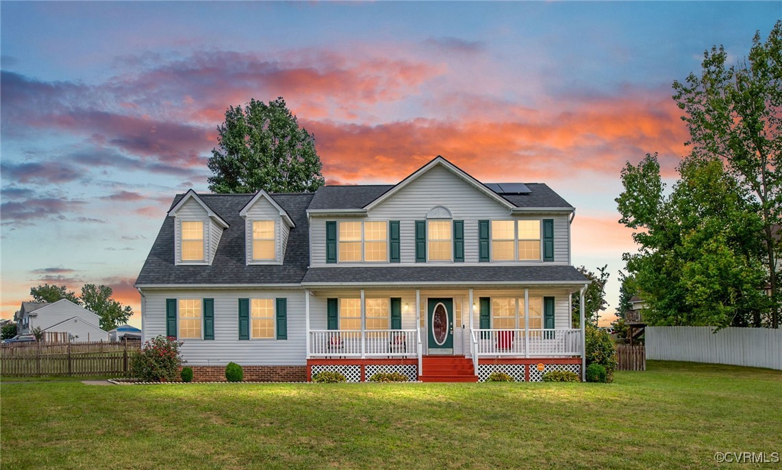 View of front of home with a lawn and covered porc