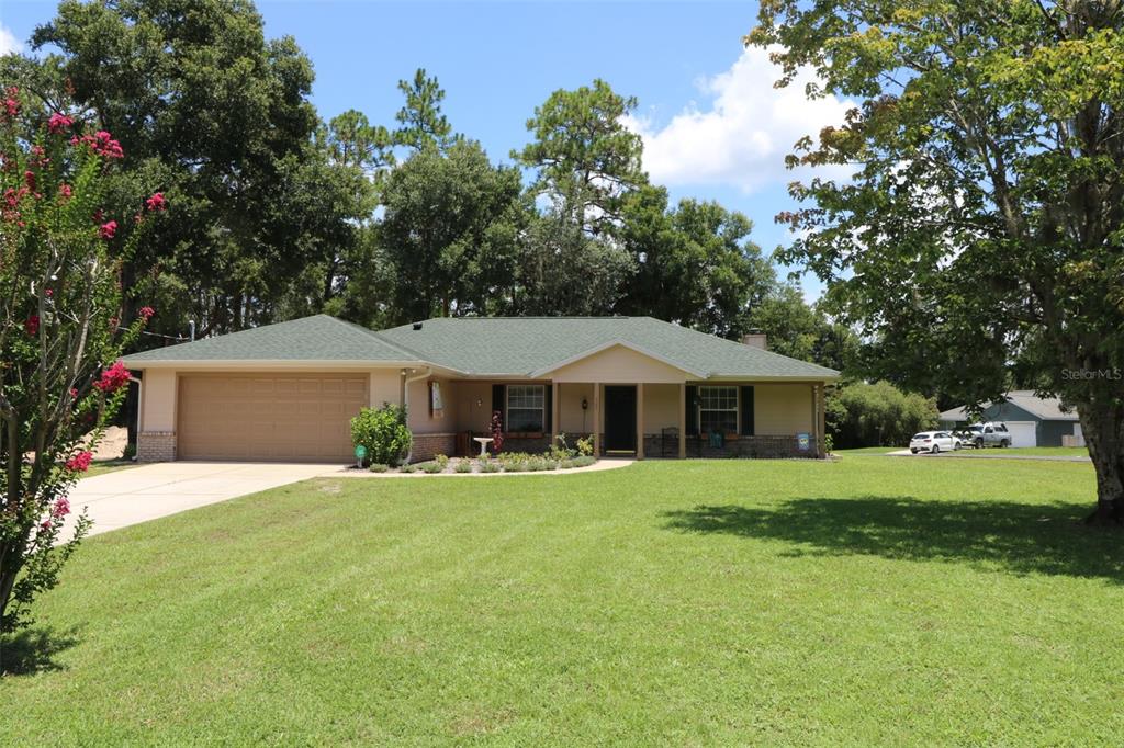 a front view of a house with a yard and trees