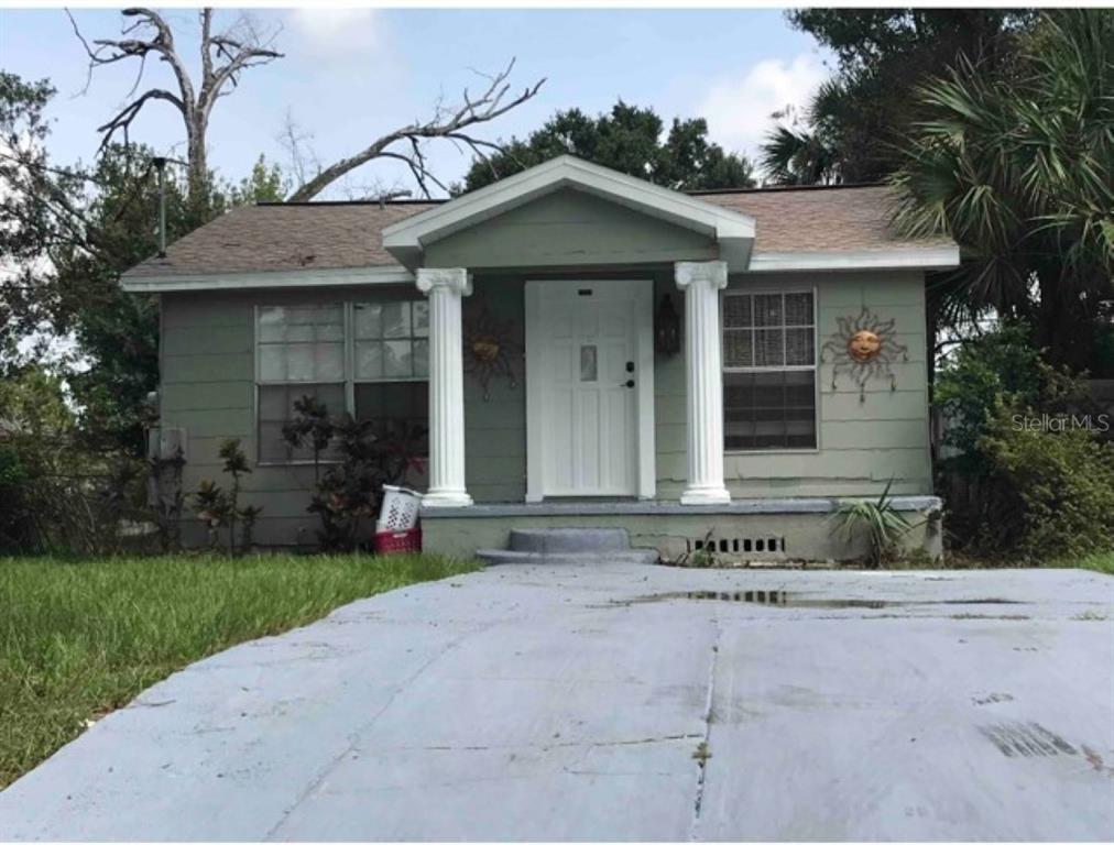 a view of house with yard and outdoor seating