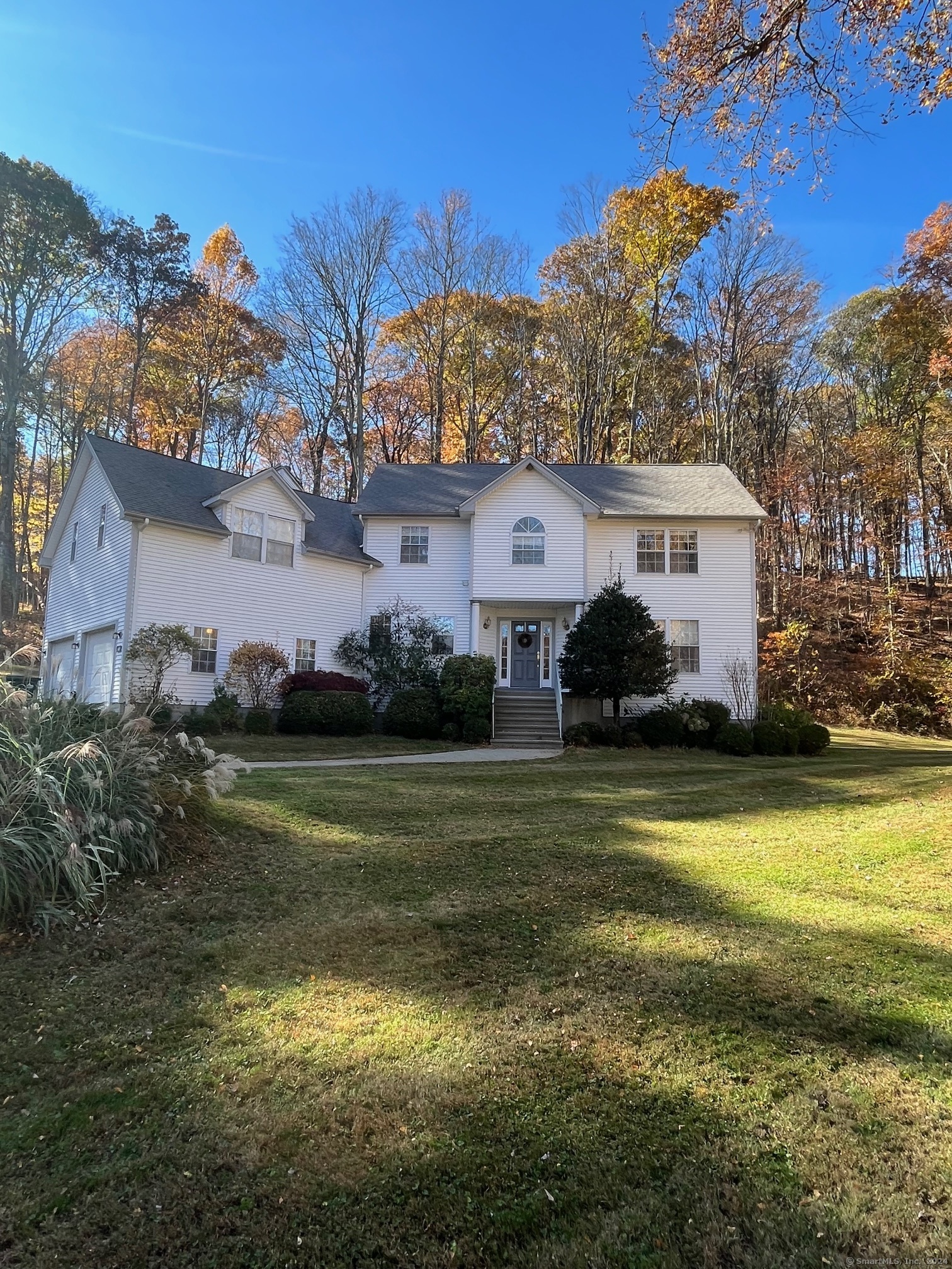 a front view of a house with a yard and swimming pool