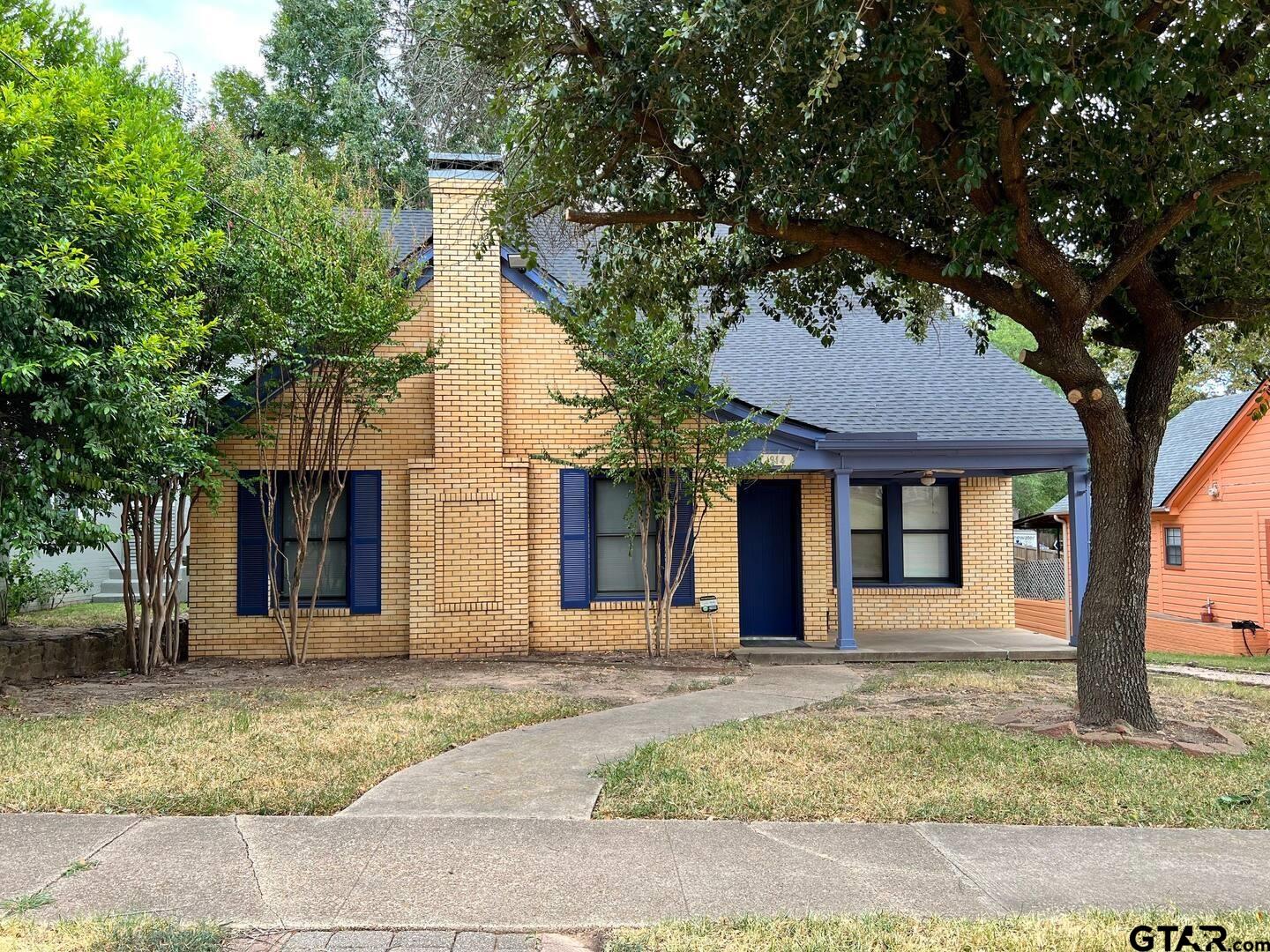 front view of a house with a tree