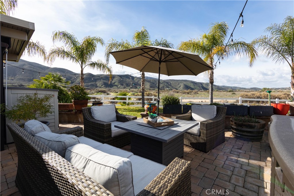 a view of a patio with couches chairs under an umbrella