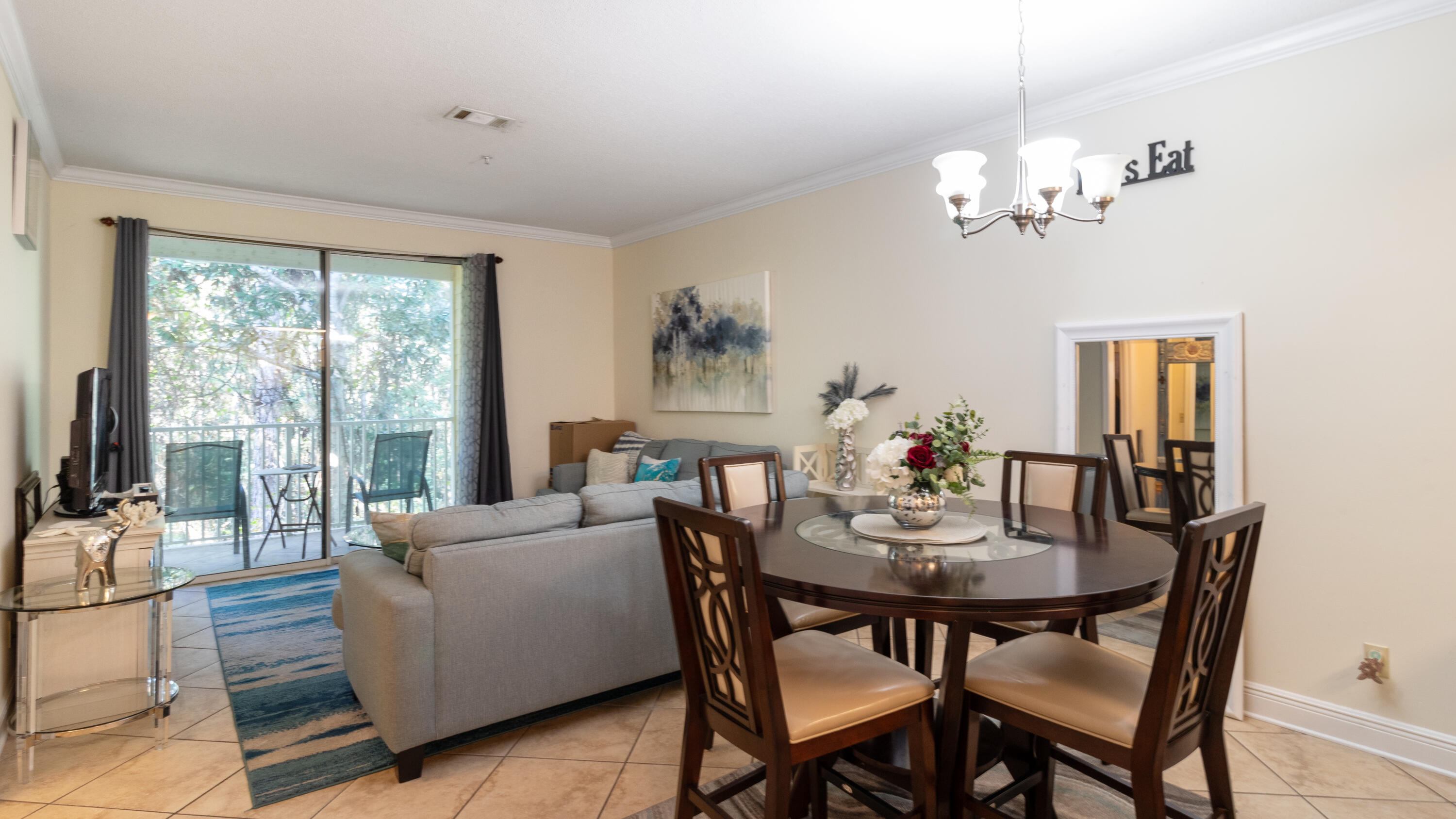 a living room with furniture dining table and a chandelier