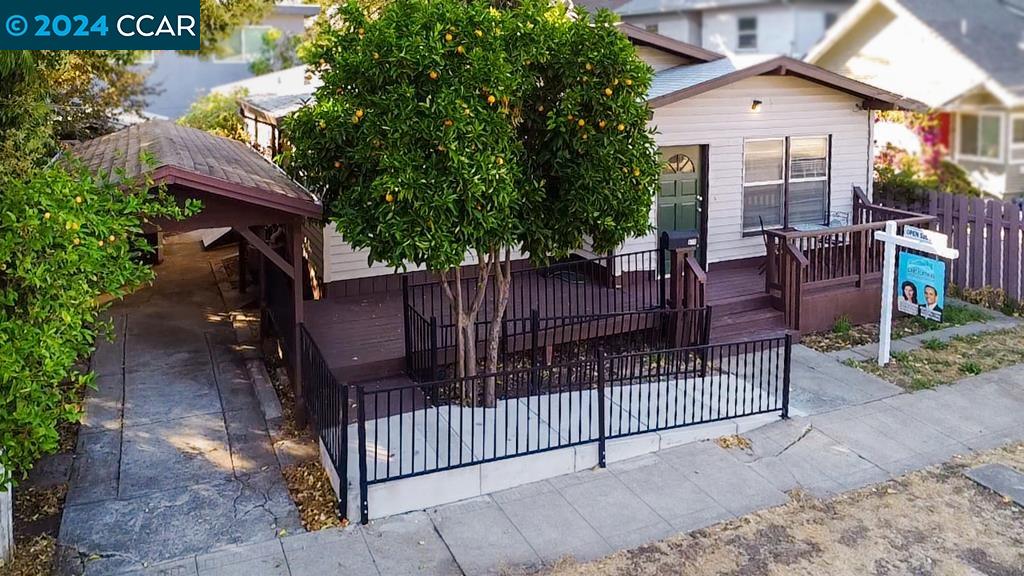 a view of house with wooden fence and trees