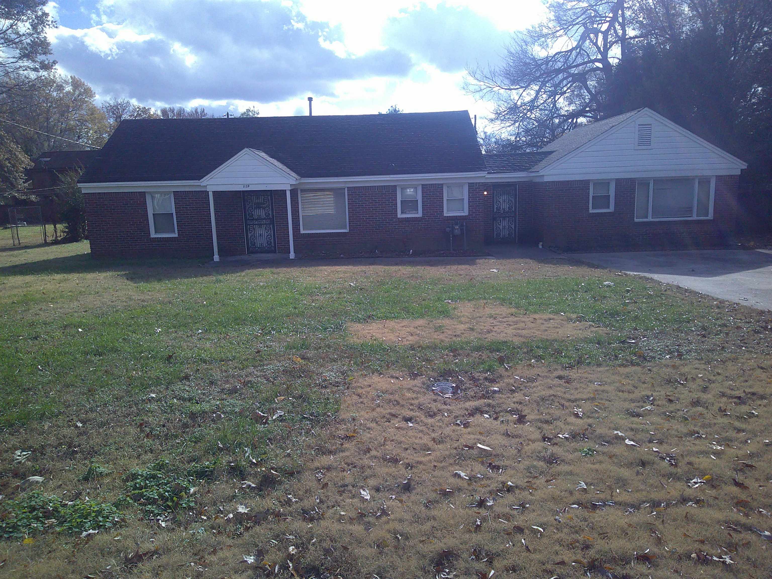 a view of a yard in front of a house with large trees