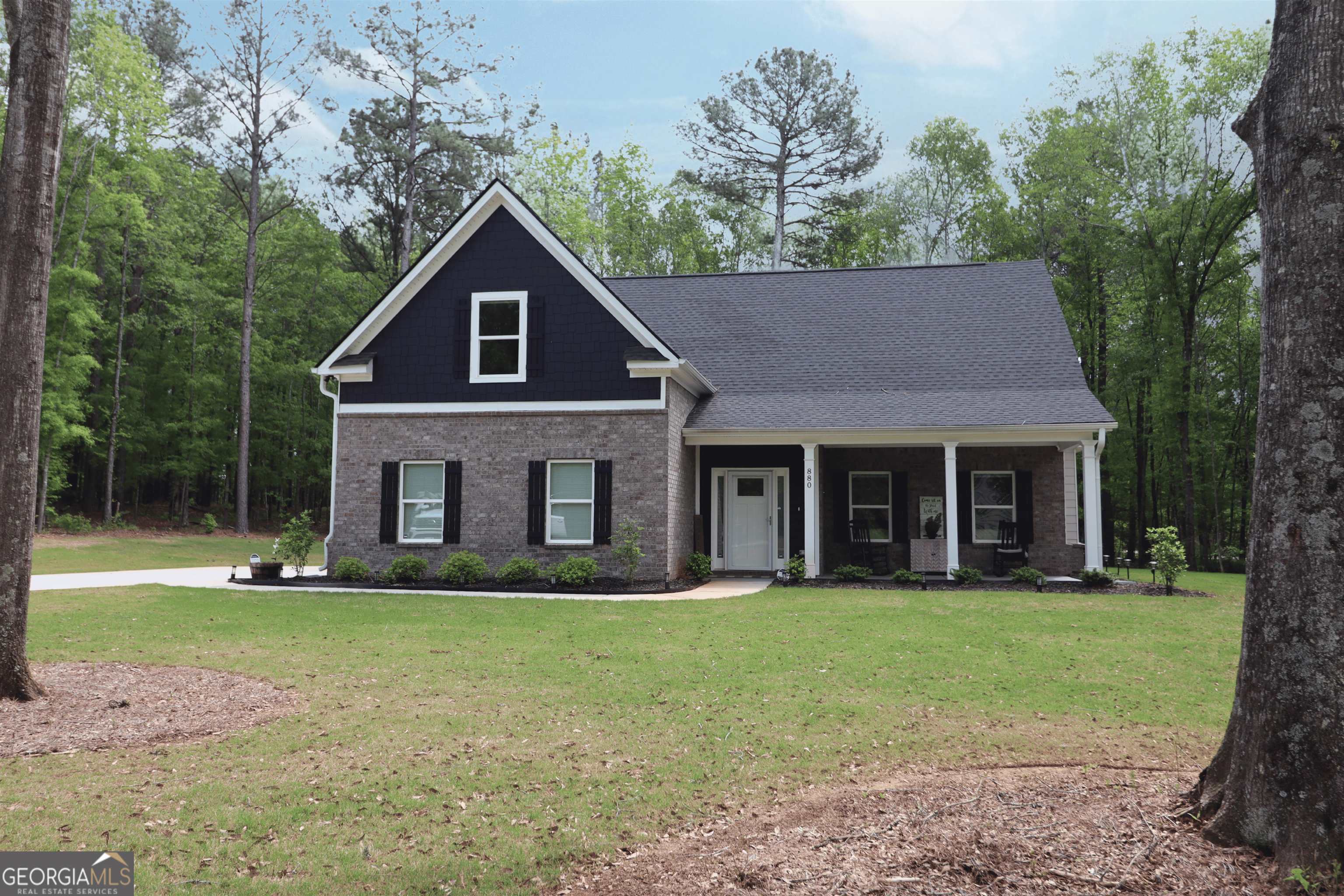 a front view of a house with yard and green space