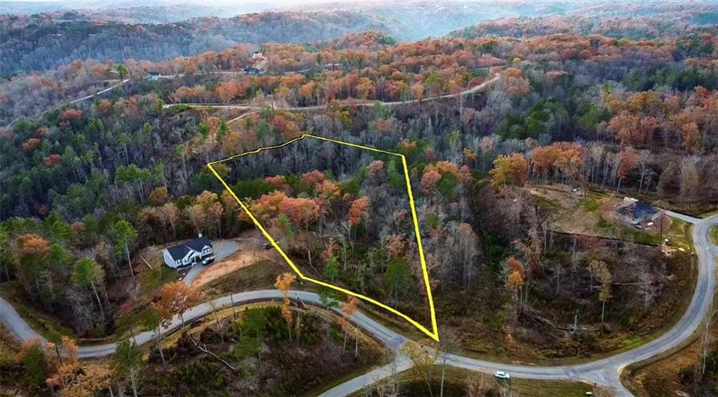 an aerial view of a house with a forest