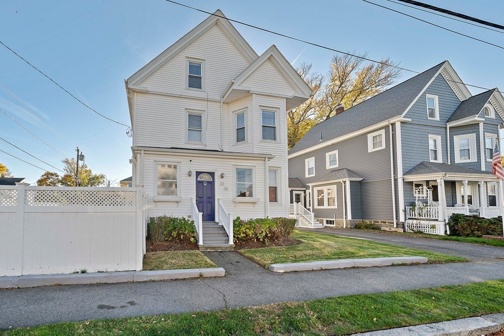 a view of a white house next to a yard