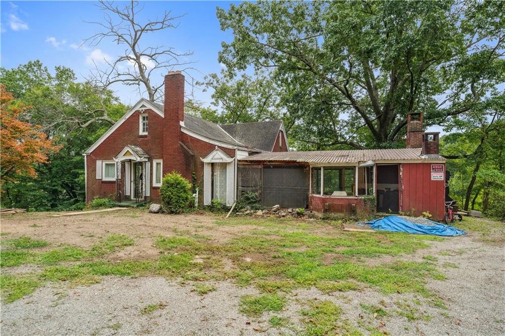 a front view of house with yard and trees in the background