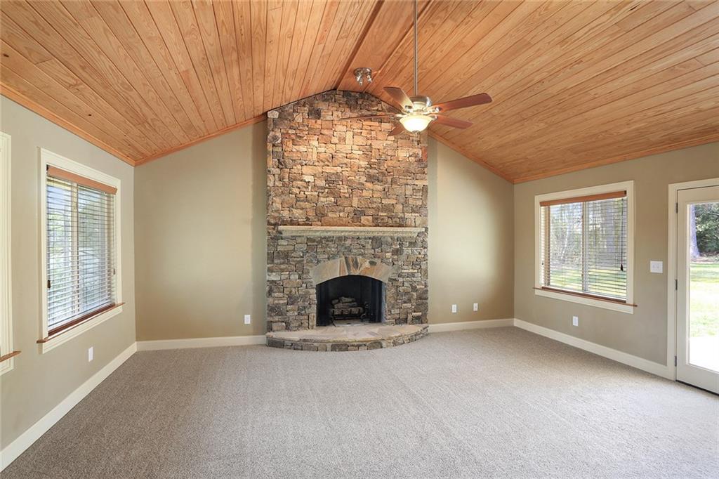 a view of an empty room with a fireplace and a window