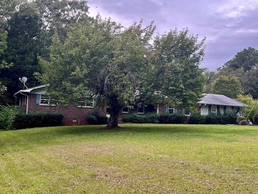 a view of a house with a yard and sitting area