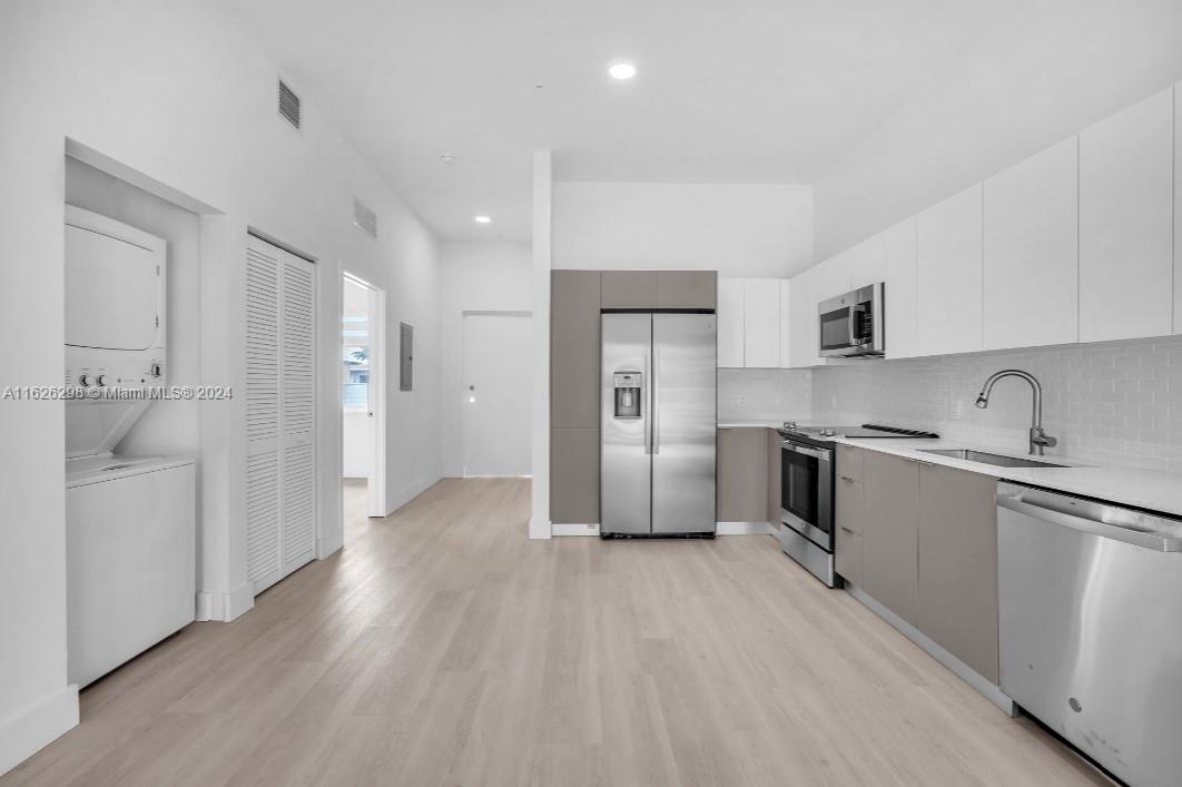 a kitchen with stainless steel appliances a refrigerator sink and cabinets