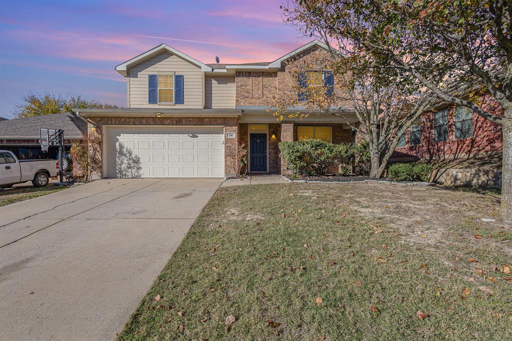 View of property featuring a yard and a garage