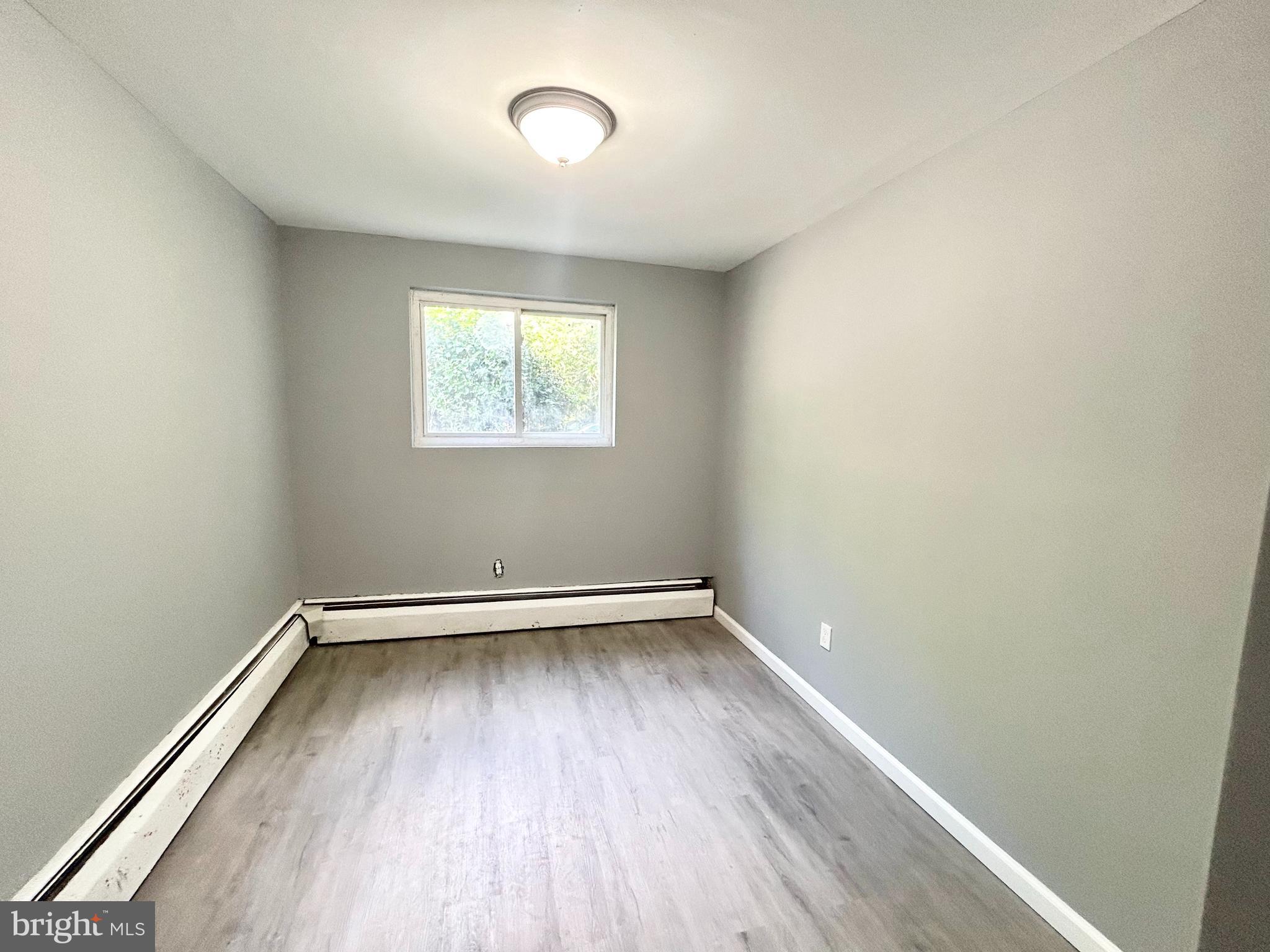 an empty room with a hardwood and a window