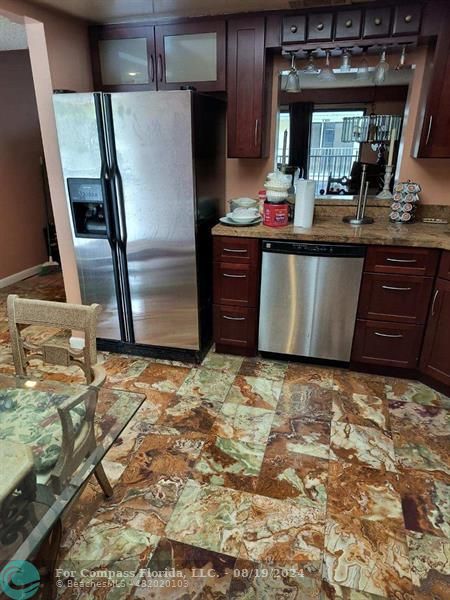 a kitchen with granite countertop a refrigerator and a stove