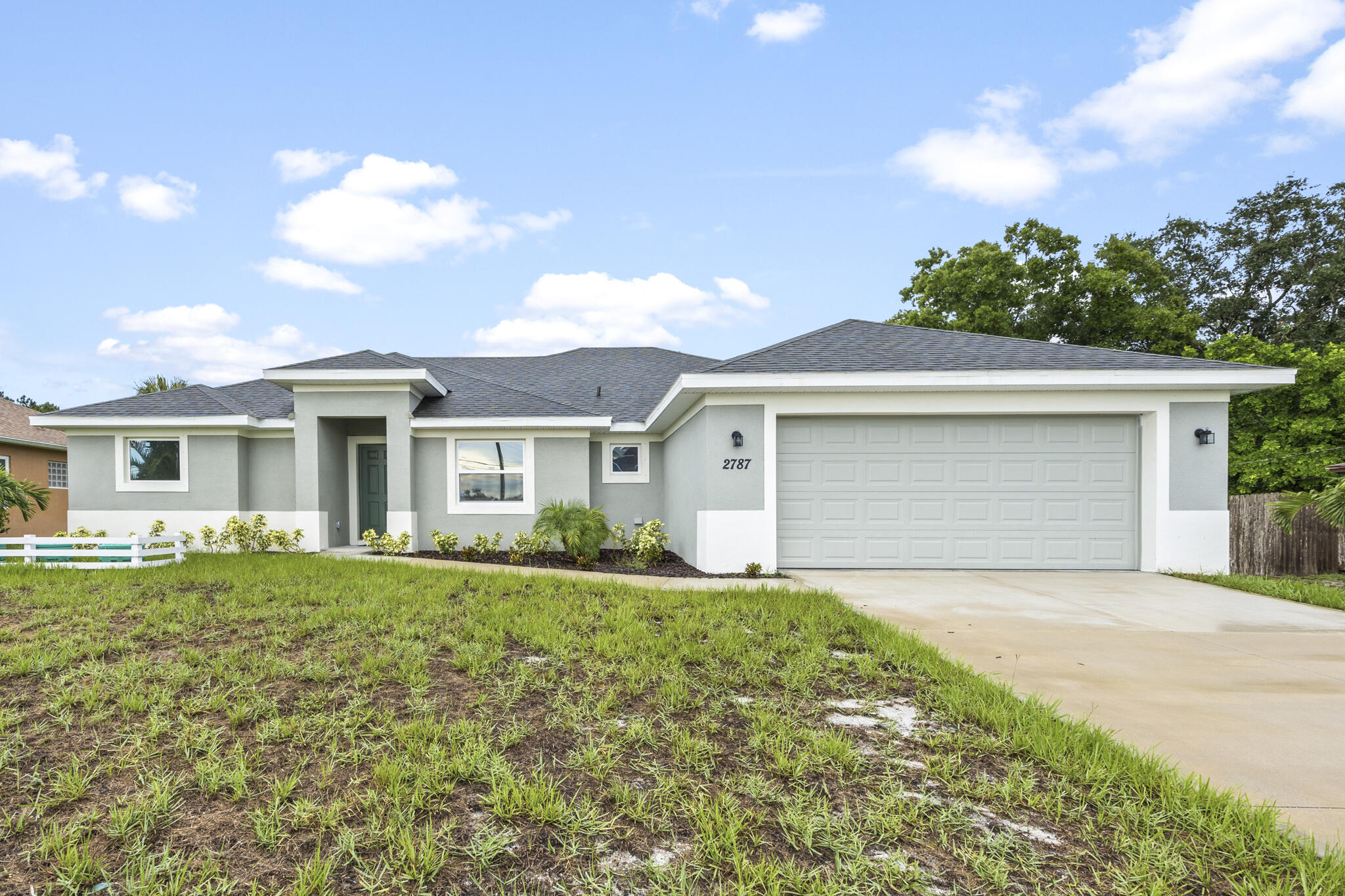 a front view of a house with a garden and yard