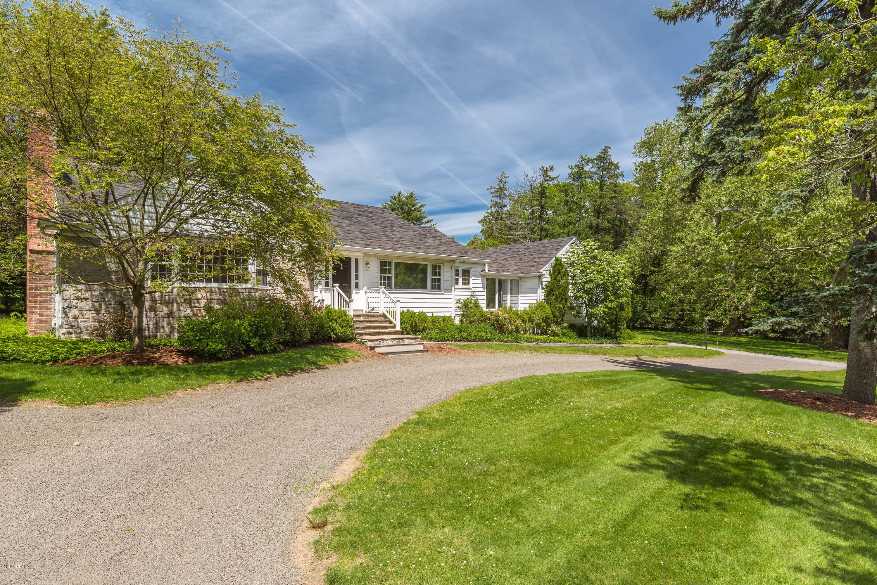 a front view of a house with a yard and trees