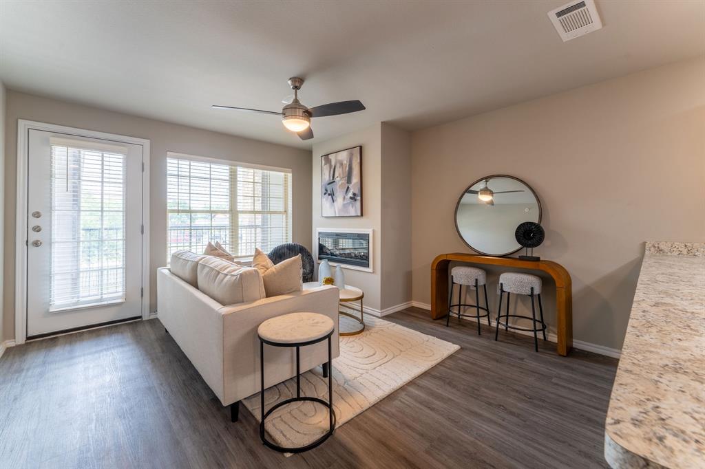 a living room with furniture a window and wooden floor