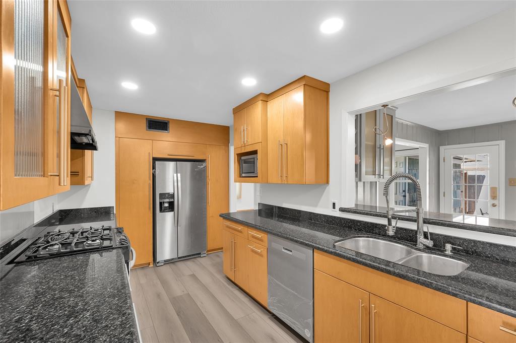 a kitchen with granite countertop a sink and a refrigerator