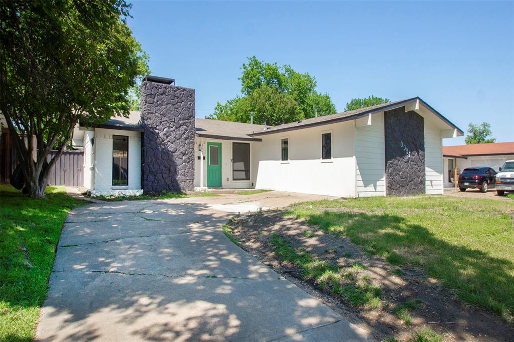 a front view of house with yard and trees in the background