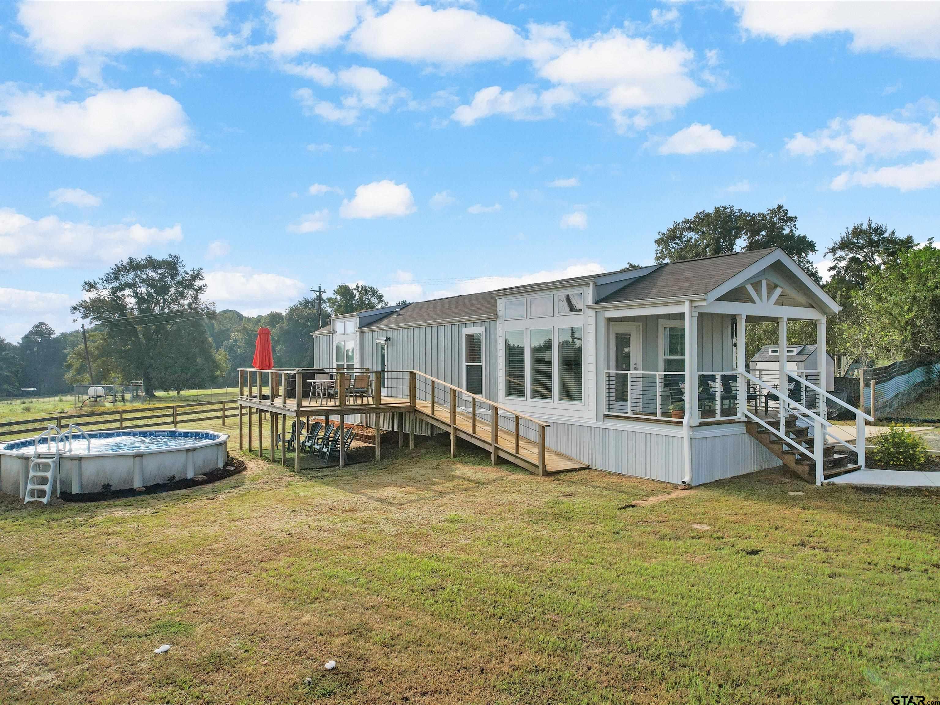 a view of a house with swimming pool and sitting area