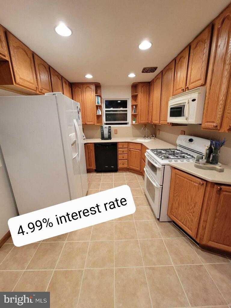 a view of kitchen with stainless steel appliances granite countertop a sink and cabinets